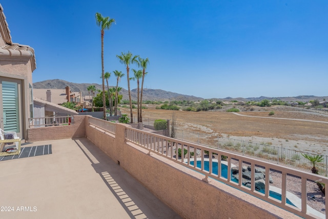 balcony featuring a mountain view and a patio