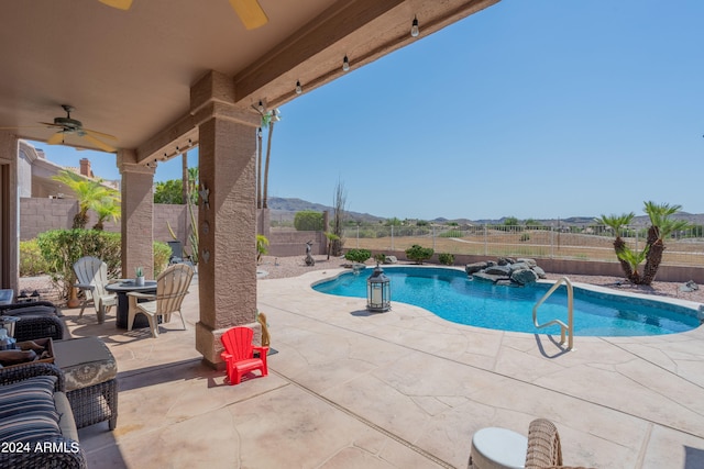 view of pool featuring a patio, a mountain view, and ceiling fan