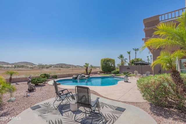 view of swimming pool with a patio and a mountain view