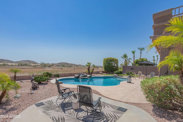 view of pool featuring a mountain view and a patio