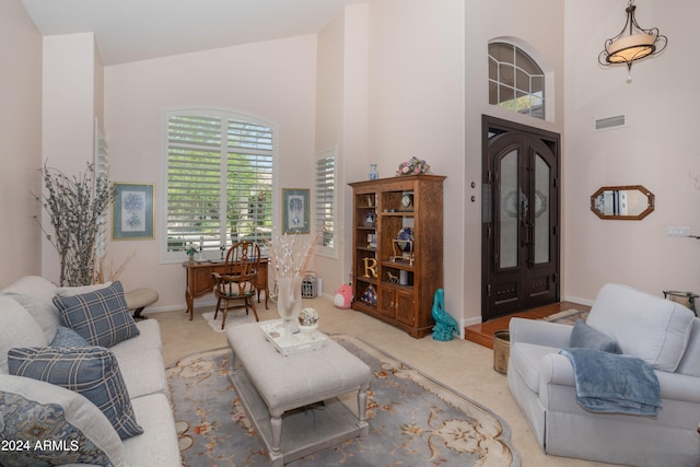 carpeted living room featuring a high ceiling