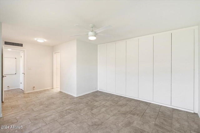 empty room featuring ceiling fan, visible vents, and baseboards