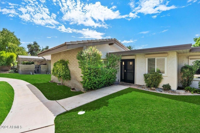 single story home featuring stucco siding, brick siding, and a front yard