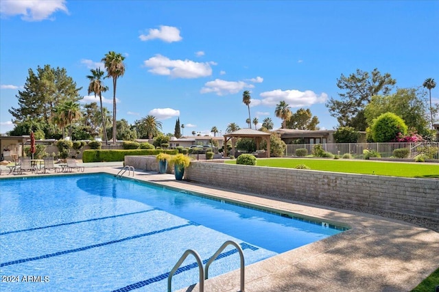 view of swimming pool featuring a lawn and a patio