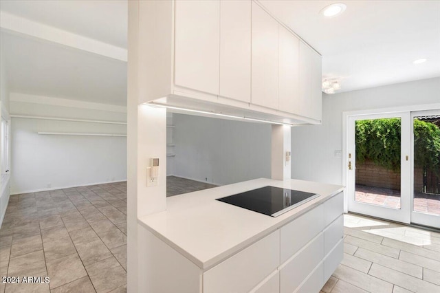 kitchen with modern cabinets, black electric stovetop, light countertops, white cabinetry, and recessed lighting