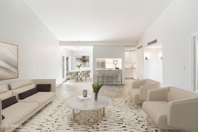 living room featuring light tile patterned floors and high vaulted ceiling