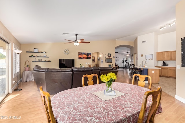 dining room with ceiling fan, light wood-type flooring, and lofted ceiling