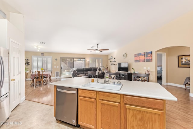 kitchen featuring appliances with stainless steel finishes, light hardwood / wood-style flooring, sink, and a center island