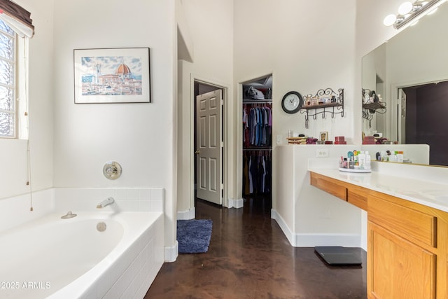 bathroom featuring a tub, concrete flooring, and vanity