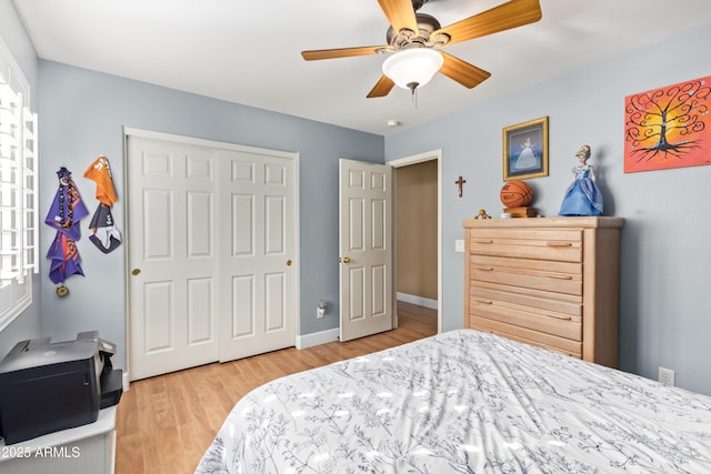 bedroom with ceiling fan, light hardwood / wood-style floors, and a closet