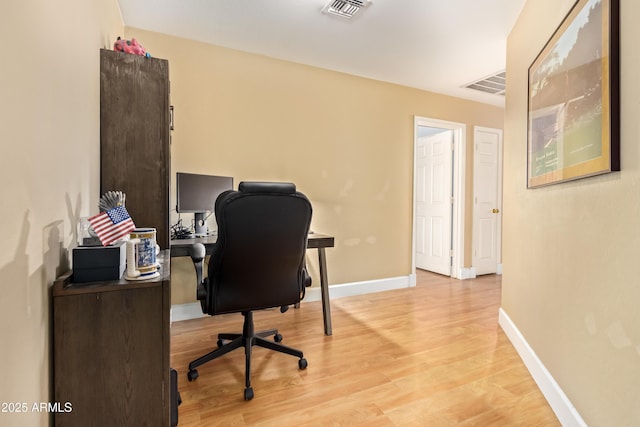 home office with light hardwood / wood-style floors