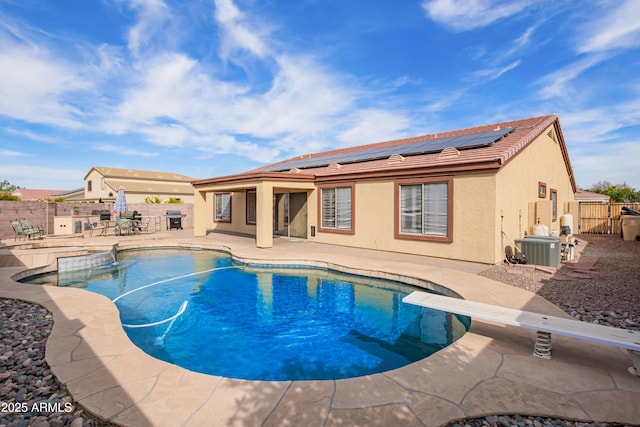 view of swimming pool featuring central AC, a diving board, and a patio area