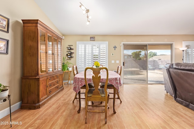 dining area featuring light hardwood / wood-style floors and vaulted ceiling