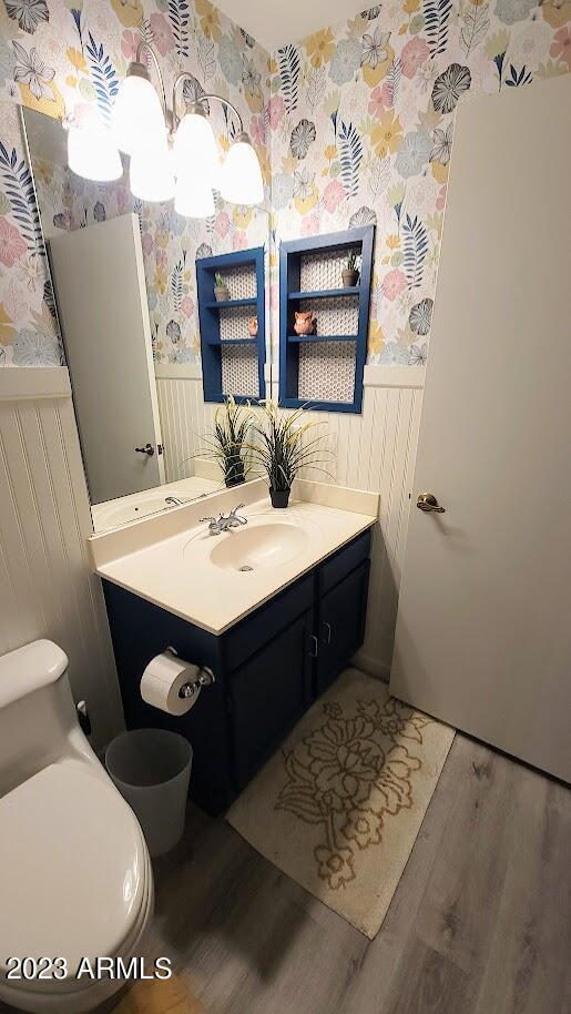 2723 E Rockledge Rd, Phoenix, AZ 85048 - half bathroom featuring wallpapered walls, wainscoting, wood finished floors, and vanity
