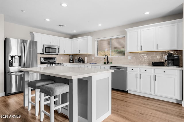 35360 N 93rd Way, Scottsdale, AZ 85262 - kitchen featuring appliances with stainless steel finishes, a sink, white cabinetry, a kitchen island, and light wood-style flooring