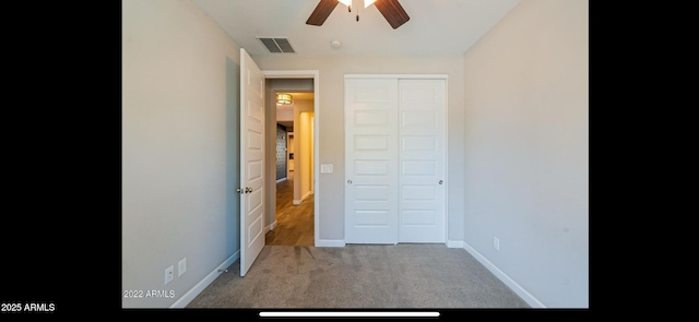 unfurnished bedroom with a closet, a ceiling fan, visible vents, carpet floors, and baseboards