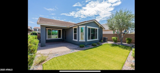 back of property with fence, a patio, a lawn, and stucco siding
