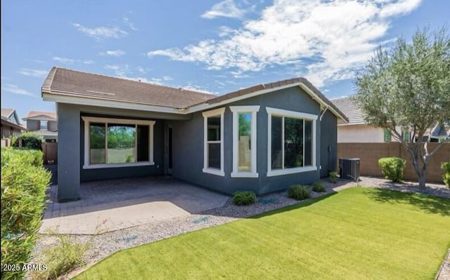 rear view of property with stucco siding, a lawn, a patio area, fence, and central AC unit