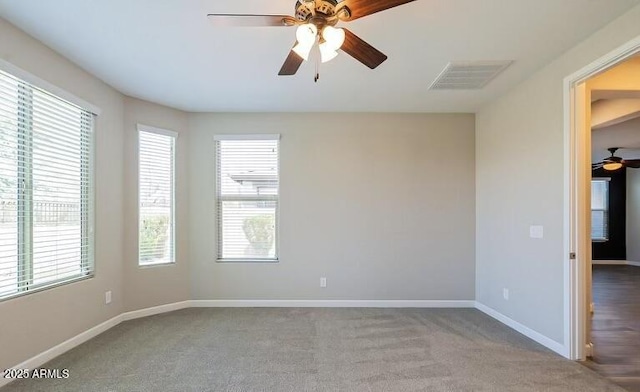 unfurnished room featuring visible vents, baseboards, a ceiling fan, and carpet floors