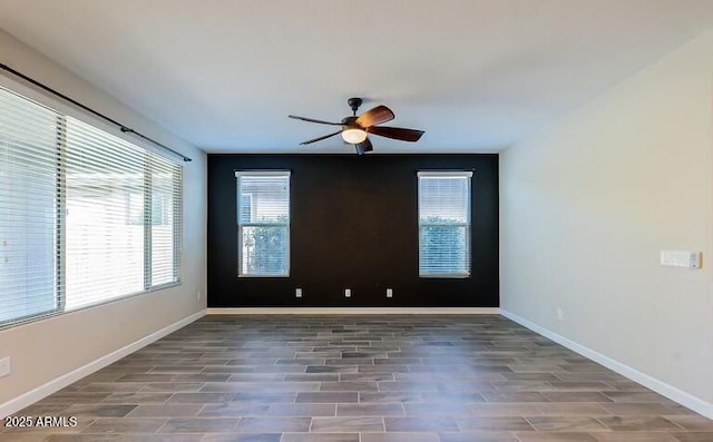 unfurnished room with baseboards, a ceiling fan, and wood finished floors