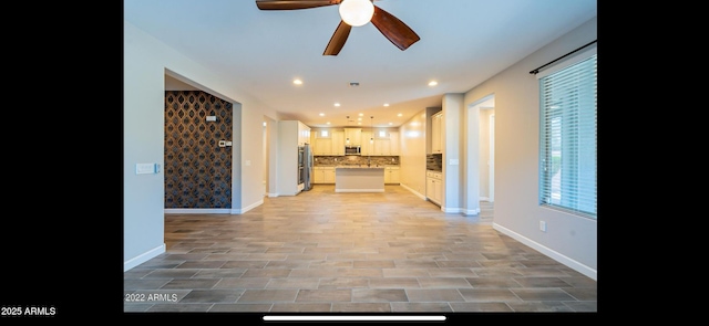 unfurnished living room with recessed lighting, baseboards, and a ceiling fan