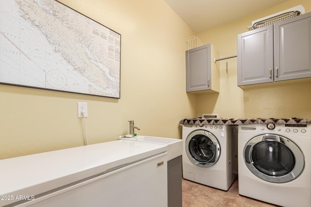 laundry area with light tile patterned floors, a sink, cabinet space, and separate washer and dryer