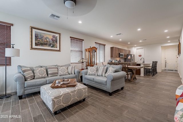 living area with wood tiled floor, visible vents, and recessed lighting