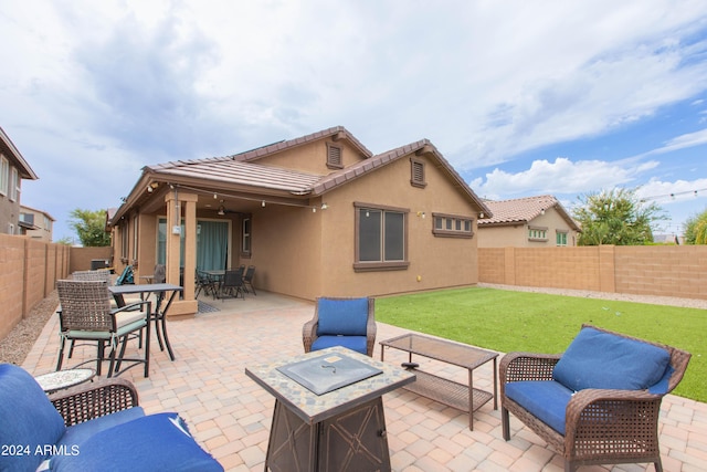 rear view of property with an outdoor fire pit, a fenced backyard, a tiled roof, a patio area, and stucco siding