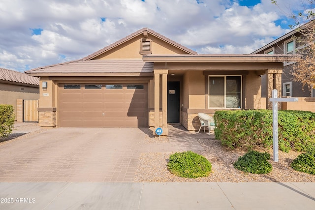 single story home with an attached garage, a tile roof, decorative driveway, and stucco siding