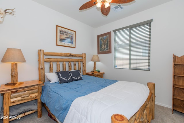 carpeted bedroom featuring a ceiling fan, visible vents, and baseboards