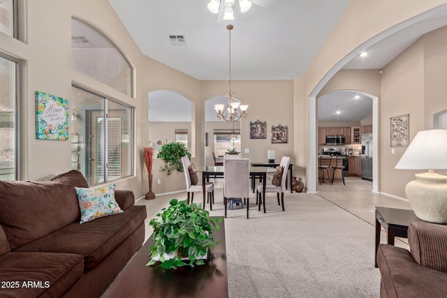 living room featuring a high ceiling, light carpet, and a notable chandelier