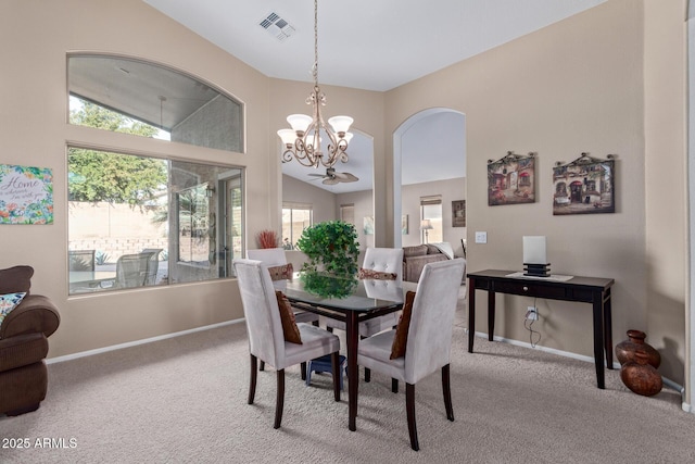 carpeted dining room featuring an inviting chandelier, high vaulted ceiling, and a healthy amount of sunlight