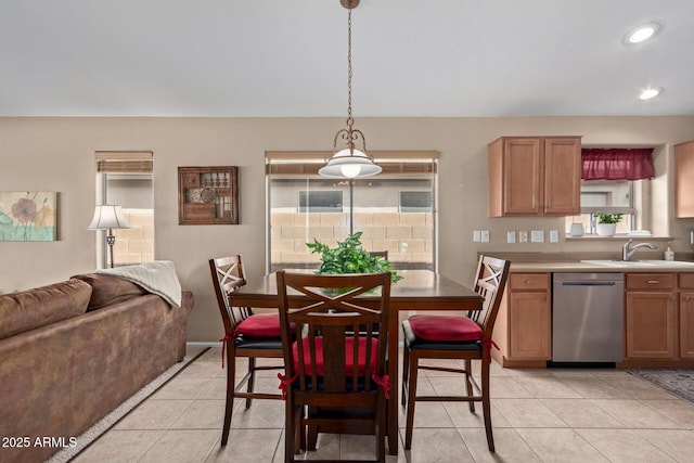 kitchen featuring sink, decorative light fixtures, dishwasher, and light tile patterned flooring