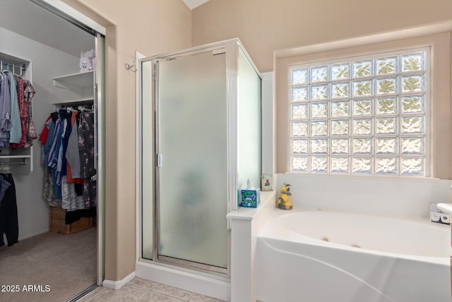 bathroom featuring tile patterned flooring, plenty of natural light, and separate shower and tub