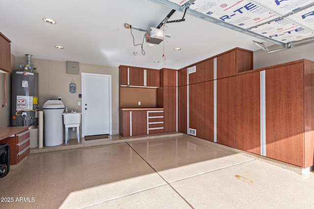 garage with a garage door opener, sink, and water heater