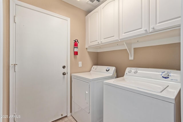 clothes washing area with washing machine and dryer and cabinets