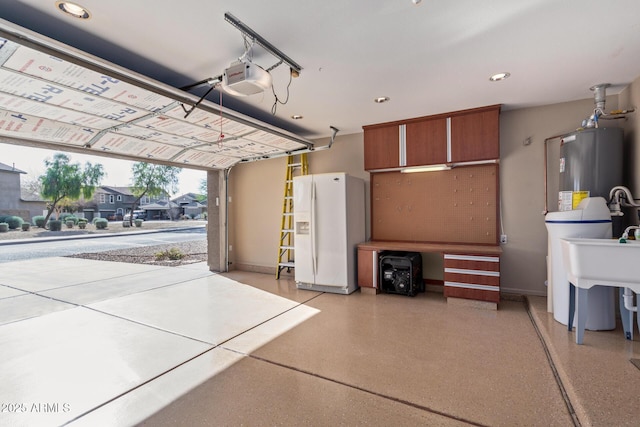 garage featuring water heater, a garage door opener, and white fridge with ice dispenser