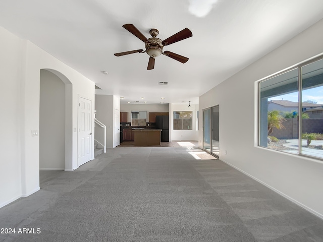 unfurnished living room with ceiling fan and light carpet