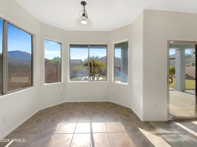 unfurnished room with light tile patterned floors and plenty of natural light