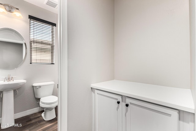 21972 N 97th Gln, Peoria, AZ 85383 - half bath with visible vents, wood finished floors, toilet, baseboards, and a sink