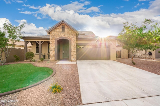21972 N 97th Gln, Peoria, AZ 85383 - mediterranean / spanish-style house with fence, an attached garage, stone siding, stucco siding, and driveway