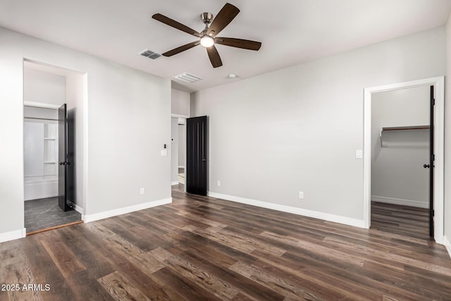 21972 N 97th Gln, Peoria, AZ 85383 - unfurnished bedroom featuring visible vents, dark wood finished floors, a walk in closet, and baseboards