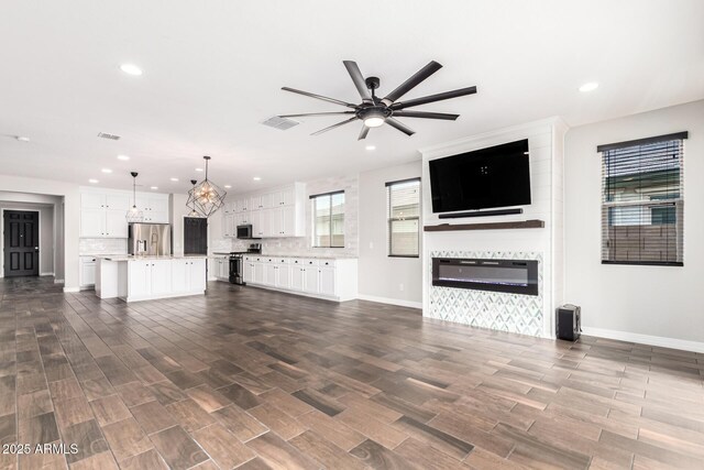 21972 N 97th Gln, Peoria, AZ 85383 - unfurnished living room with recessed lighting, ceiling fan, and a fireplace