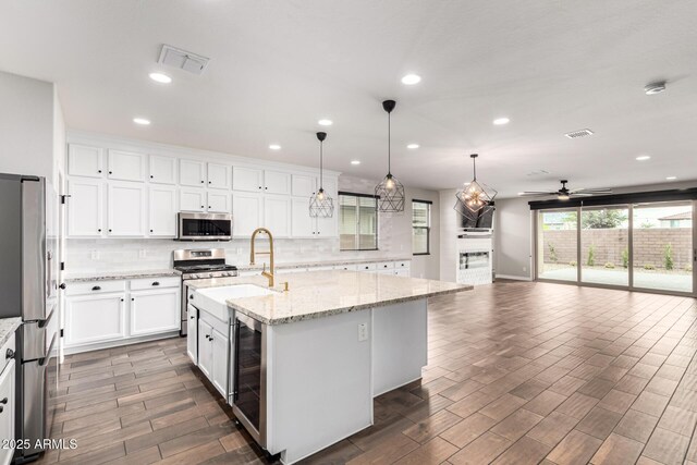 21972 N 97th Gln, Peoria, AZ 85383 - kitchen featuring beverage cooler, decorative backsplash, appliances with stainless steel finishes, and ceiling fan
