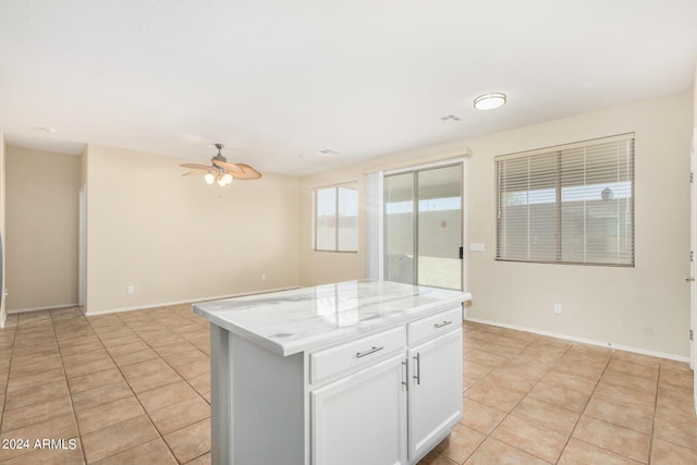 kitchen with white cabinetry, a center island, light tile patterned floors, and ceiling fan