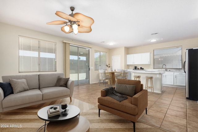 living room with ceiling fan, light tile patterned floors, and sink