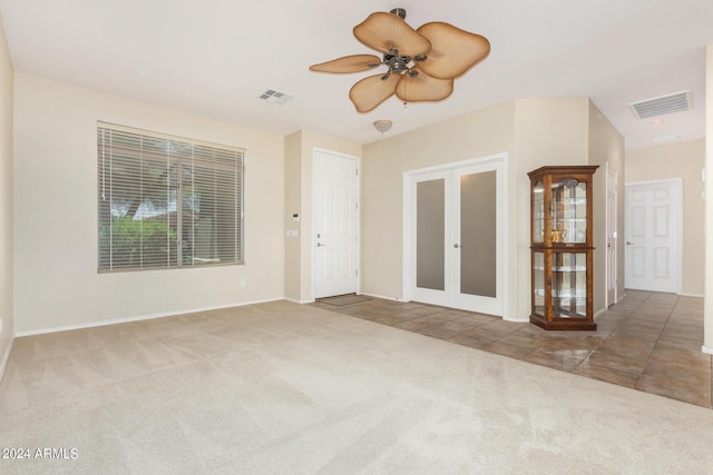 spare room with ceiling fan, french doors, and carpet