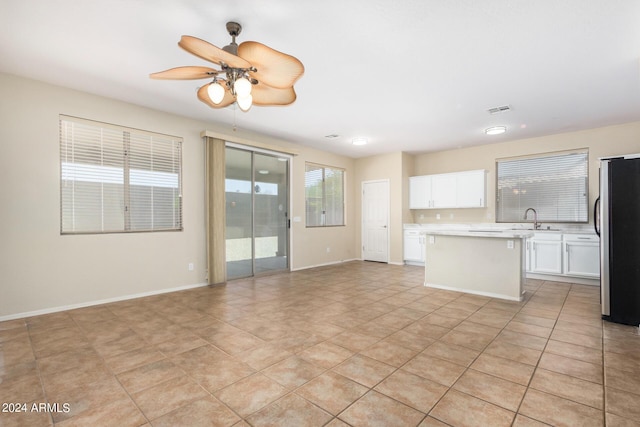 unfurnished living room with light tile patterned floors, ceiling fan, and sink