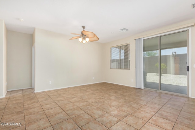 tiled empty room featuring ceiling fan