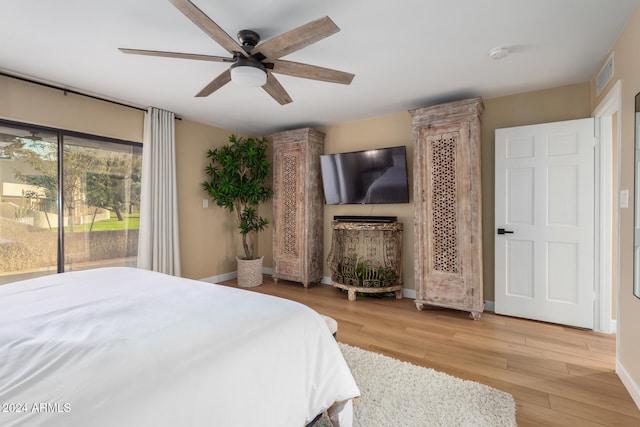 bedroom featuring access to outside, hardwood / wood-style flooring, and ceiling fan